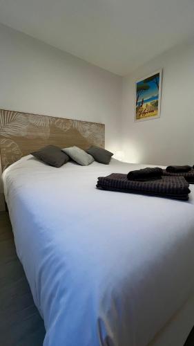 a large white bed sitting in a room at Vacances Arbanaises - Appartements Giens in Hyères