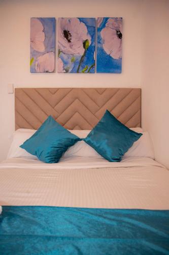 a bedroom with a bed with two blue pillows at CASA PETRA in Cartagena de Indias
