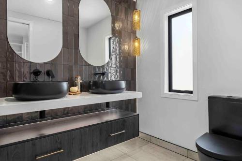 a bathroom with two sinks and a mirror at Luxury Escape in CBD - Walking Distance To Town in Tauranga