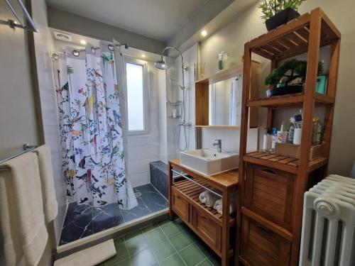 bagno con tenda per la doccia e lavandino di location chambre chez l'habitant a Épinay-sur-Seine