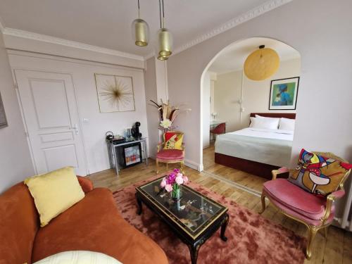 un soggiorno con letto, divano e tavolo di location chambre chez l'habitant a Épinay-sur-Seine