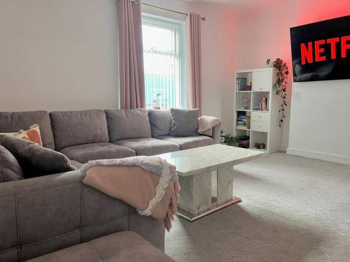 sala de estar con sofá y mesa de centro en Spacious Modern Duplex Apartment en Rochdale