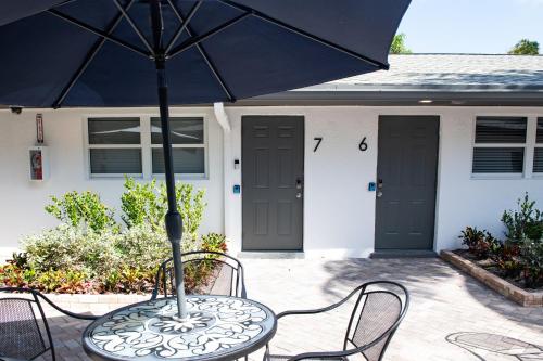 a table with an umbrella in front of a house at The Lauderdale Boutique Hotel in Fort Lauderdale