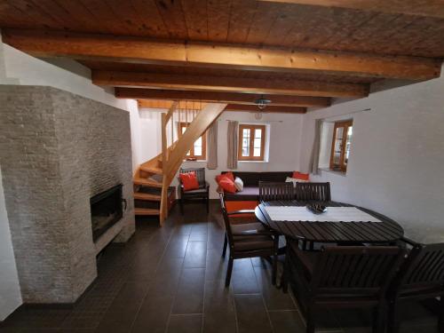 ein Wohnzimmer mit einem Tisch, Stühlen und einem Kamin in der Unterkunft Sweet Country House in Markovci