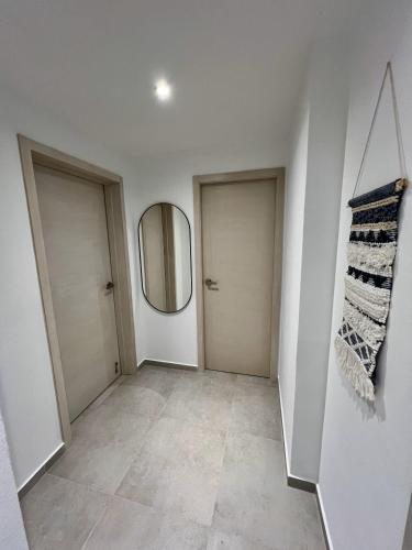 a hallway with two doors and a mirror at Komfortowy Apartament z 4 Basenami i Pięknym Ogrodem, Estrella Dominicus-Bayahibe in Bayahibe