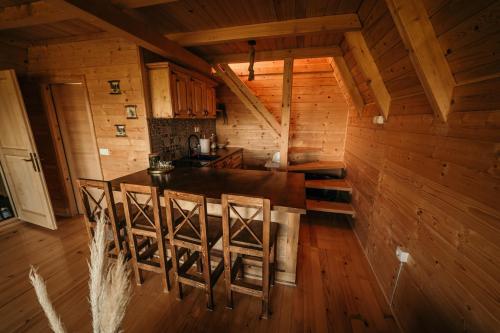 a kitchen with a table and chairs in a cabin at Uvacki raj in Radijevići