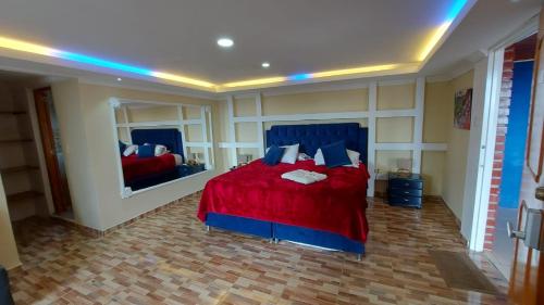 1 dormitorio con cama roja y espejo en Finca Hotel La Melania, en Montenegro