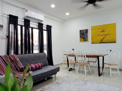 a living room with a couch and a table and chairs at Malay Homestay TEREZ138 Banda Hilir in Melaka