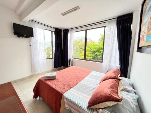een slaapkamer met een bed en een raam bij Lindo Apartaestudio Centro Pereira in Pereira