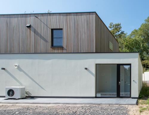 a house with a large sliding glass door at Fluithoekhoeve in Koksijde