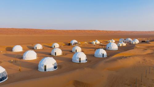 a group of domes in the desert at Luxury Desert Camp in Al Wāşil