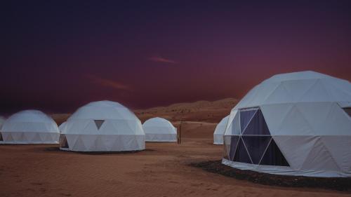 three white tents in the desert at night at Luxury Desert Camp Oman in Al Wāşil