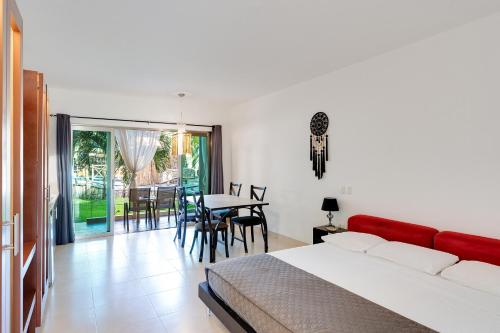 a bedroom with a bed and a table and chairs at Maia Suites Cozumel in Cozumel