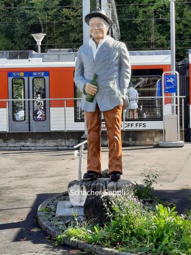 a statue of a man standing on a train station at Haus Nussbaumweg 6 in Giswil