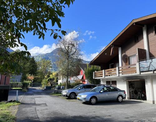 two cars parked in a parking lot next to a building at Haus Nussbaumweg 6 in Giswil