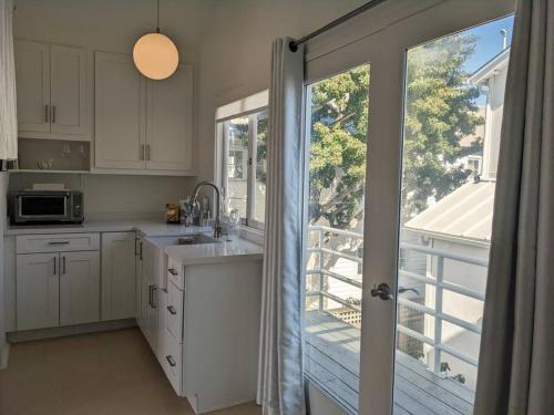 a kitchen with a sliding glass door to a balcony at Venice Canals & Beach Guest House in Los Angeles