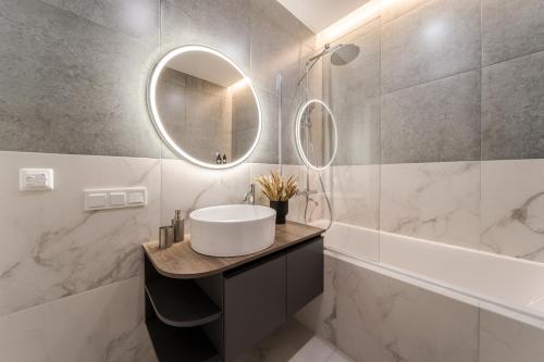 a bathroom with a sink and a mirror at 77 views apartments by INSHI in Lviv