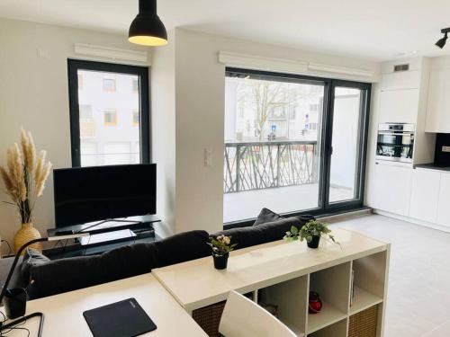 een woonkamer met een bank en een tafel bij New One bedroom Flat- Terrace & Parking in Luxemburg