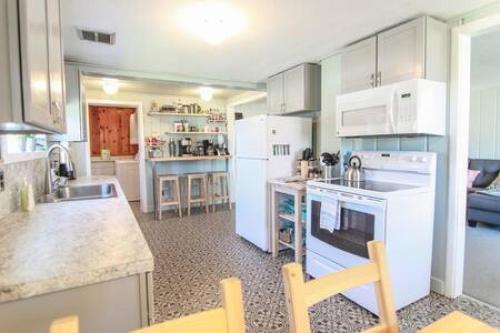 a kitchen with white appliances and a counter top at Seaside OR- Chic Family Beach Escape & Fast Wi-Fi in Seaside