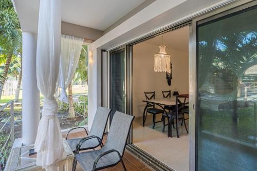 Habitación con balcón con sillas y mesa. en Maia Suites Cozumel en Cozumel