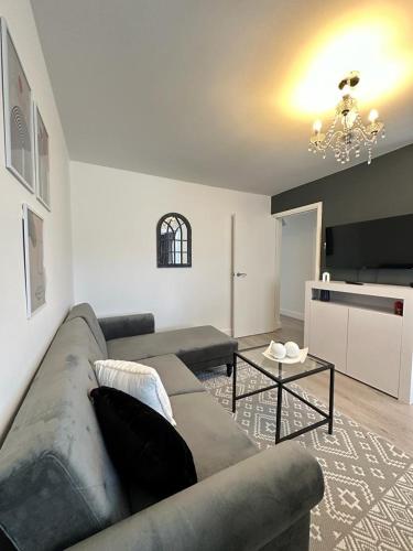 a living room with a couch and a table at Modern and spacious flat in Longbridge