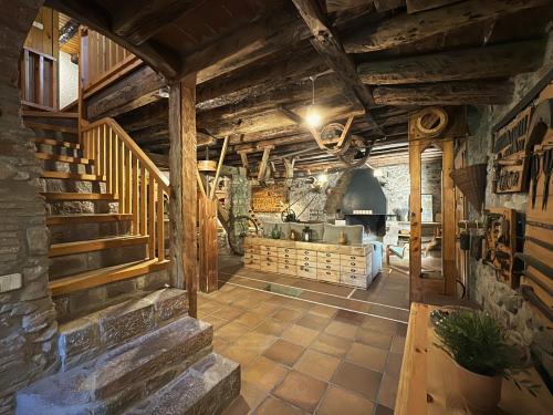 a living room with wooden stairs and a couch at Molí de Dalt in La Coma i la Pedra