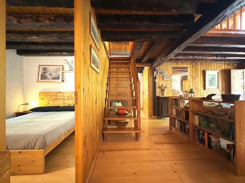 a bedroom with a bed and a wooden staircase at Molí de Dalt in La Coma i la Pedra