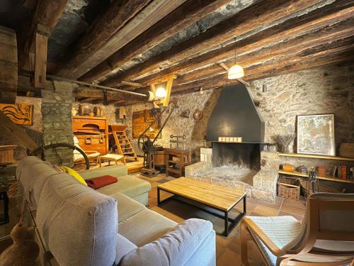 a living room with a couch and a fireplace at Molí de Dalt in La Coma i la Pedra