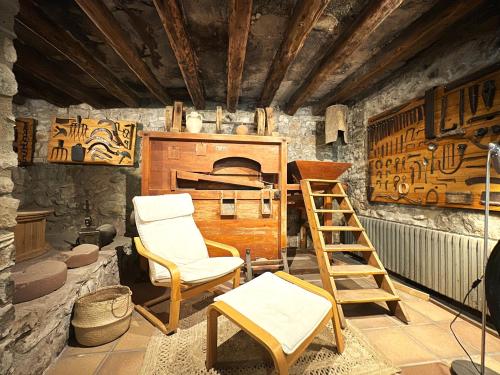 a living room with a ladder and a chair at Molí de Dalt in La Coma i la Pedra