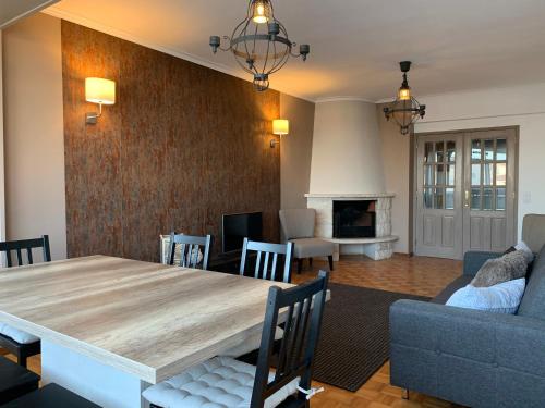 a living room with a wooden table and a couch at Girassol apartamento in Alcabideche