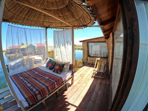 a bed on a porch with a view of the water at Luna Titicaca Bungalows in Puno
