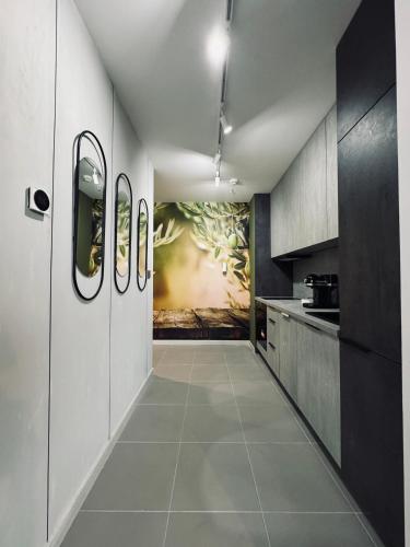 a hallway of a kitchen with a painting on the wall at Royal Kate Apartments Spa included 30th floor in Skopje
