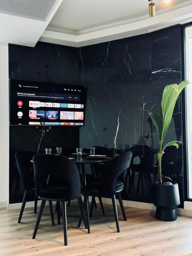 a dining room with black walls and a table and chairs at Royal Kate Apartments Spa included 30th floor in Skopje
