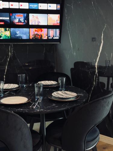 a black table with black chairs and plates on it at Royal Kate Apartments Spa included 30th floor in Skopje