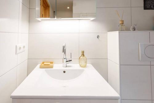 a white bathroom with a sink in a room at Exklusives Tiny House in Elbnähe in Buxtehude