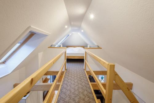 ein kleines Dachzimmer mit einem Bett und zwei Fenstern in der Unterkunft Exklusives Tiny House in Elbnähe in Buxtehude