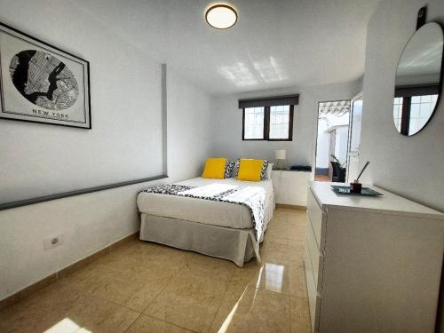 a bedroom with a bed and a desk in it at Casa BIMBA Agaete con terraza y ducha exterior in Agaete