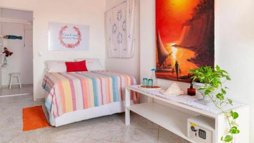 a white bedroom with a bed and a table at La Estacion Hostel - Pipa in Pipa