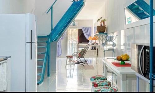 a kitchen with a blue staircase in a house at La Estacion Hostel - Pipa in Pipa