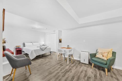 a white room with a bed and a table and chairs at 1 Bedroom Studio Close To University Of Guelph in Guelph