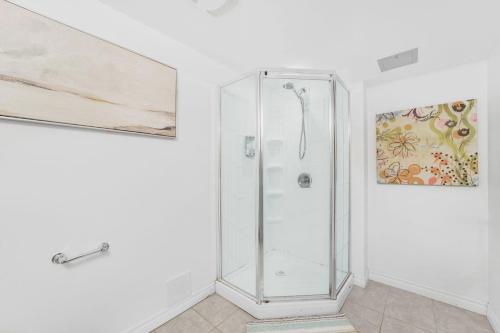 a shower stall in a white bathroom with a painting at 1 Bedroom Studio Close To University Of Guelph in Guelph