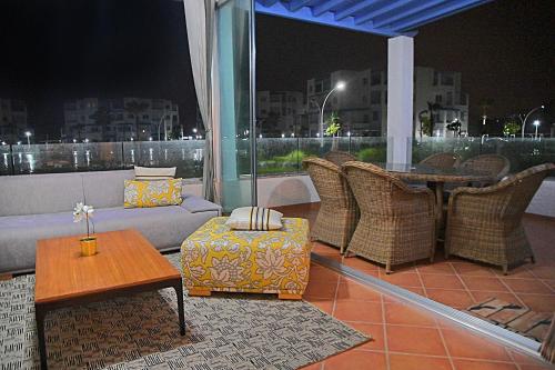 a balcony with a couch and a table and chairs at InHome Apartment in Cabo Negro