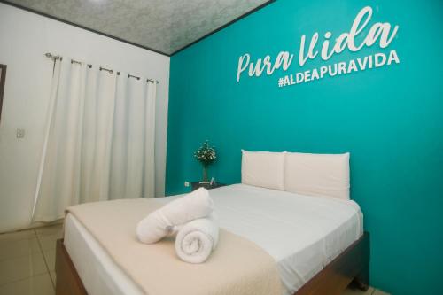 ein Hotelzimmer mit einem Bett mit Handtüchern darauf in der Unterkunft Puntarenas Bed & Coffee by Aldea in Puntarenas