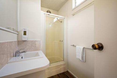a white bathroom with a sink and a shower at Bright Accommodation Park in Bright
