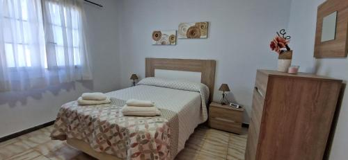 Altillo Vista Mar في Moya: غرفة نوم عليها سرير وفوط