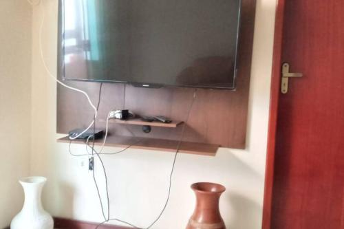 En tv och/eller ett underhållningssystem på Apto no Centro de Conservatória
