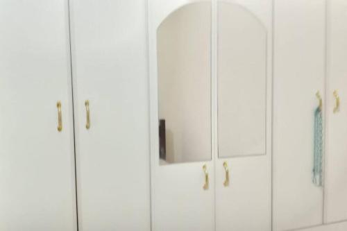 a pair of white cabinets with a mirror in them at Apto no Centro de Conservatória in Conservatória