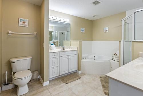 a bathroom with a toilet and a tub and a sink at Estuary Views Close to Pool Amenities Walk to Beach 9-505 in New Smyrna Beach