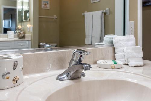 a bathroom sink with a faucet and a mirror at Estuary Views Close to Pool Amenities Walk to Beach 9-505 in New Smyrna Beach