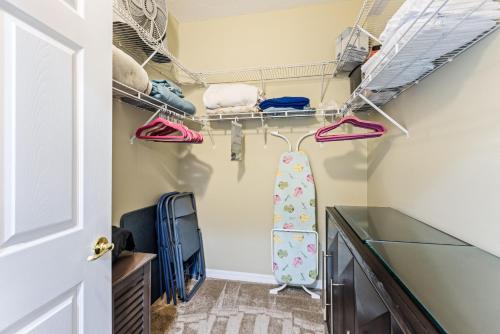a room with a closet with shoes and a tv at Estuary Views Close to Pool Amenities Walk to Beach 9-505 in New Smyrna Beach